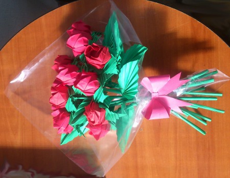 Arreglo que consta de 12 rosas envueltas en plástico y con un pequeño moño.